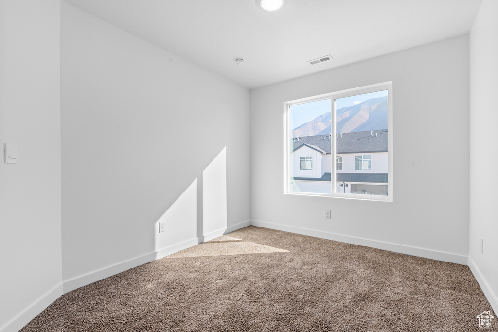Empty room featuring carpet flooring and baseboards