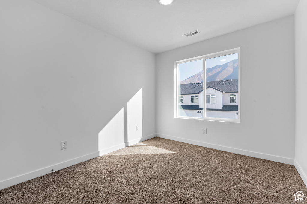 Empty room with carpet and baseboards