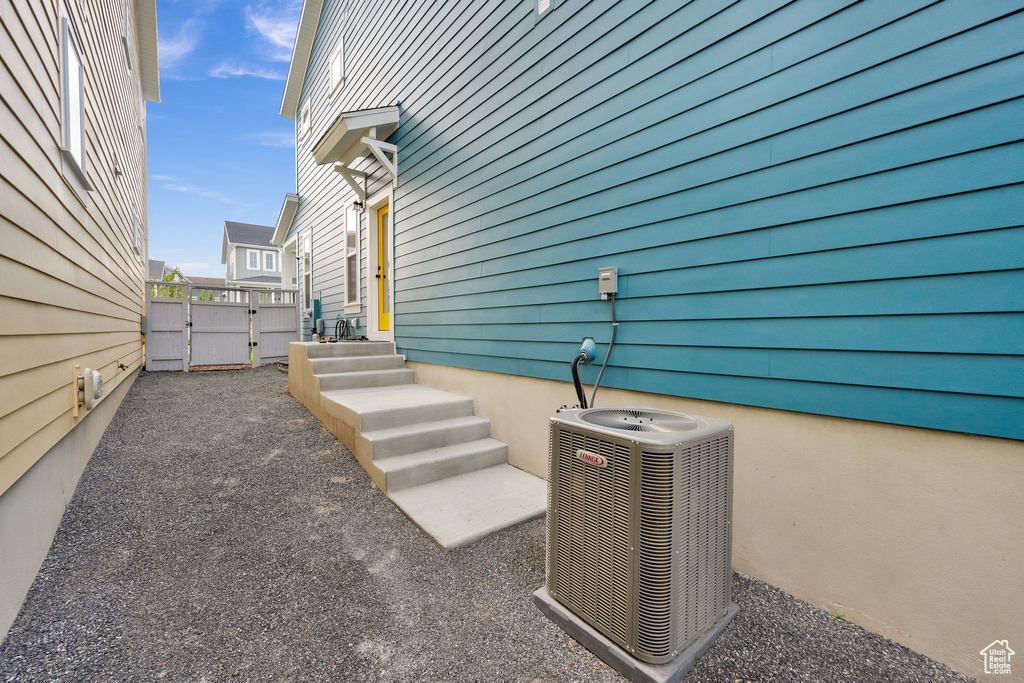 View of patio featuring cooling unit and a gate