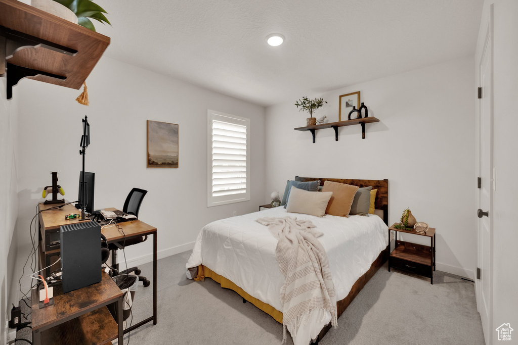 Bedroom with light colored carpet, baseboards, a desk, and recessed lighting