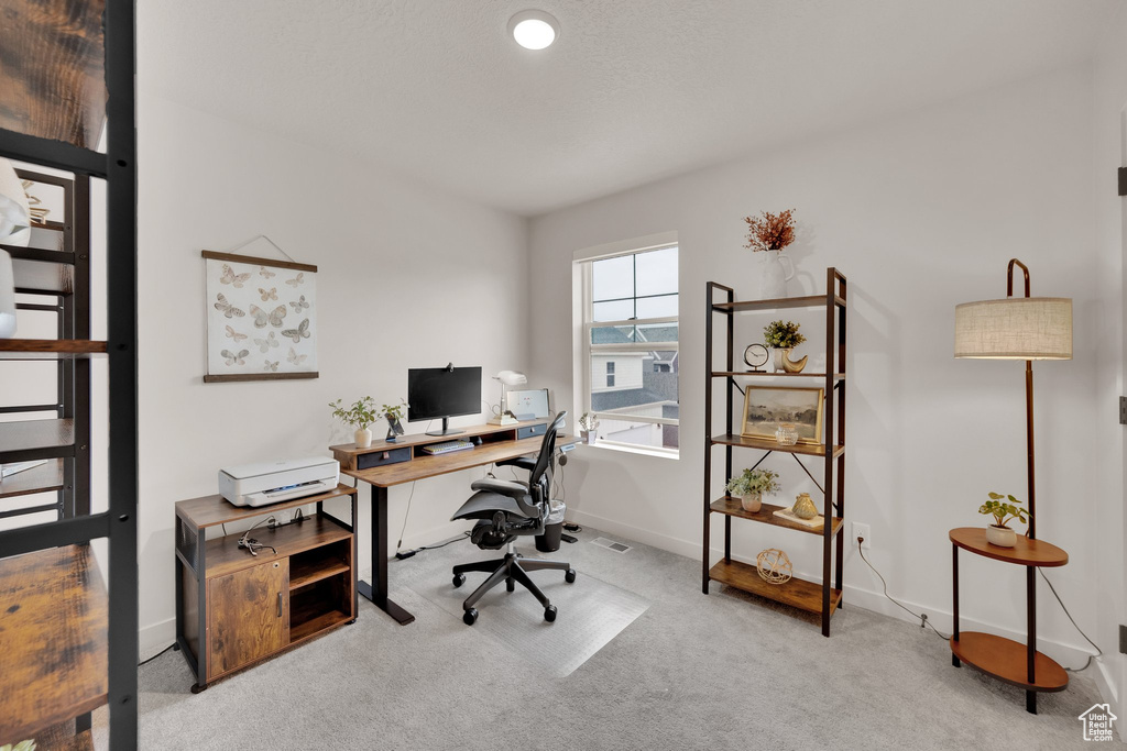 Carpeted office space with baseboards