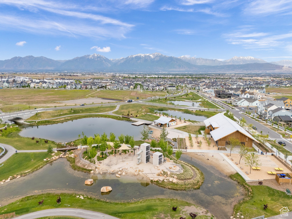 Aerial view of property and surrounding area featuring a water and mountain view and nearby suburban area