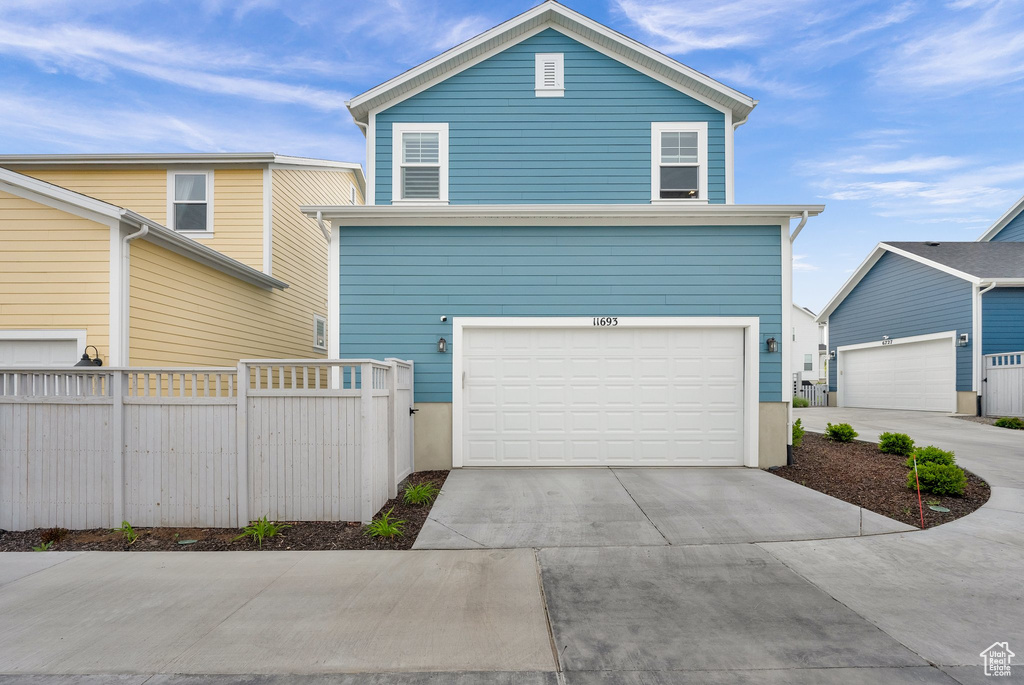 View of front of property featuring concrete driveway and an attached garage