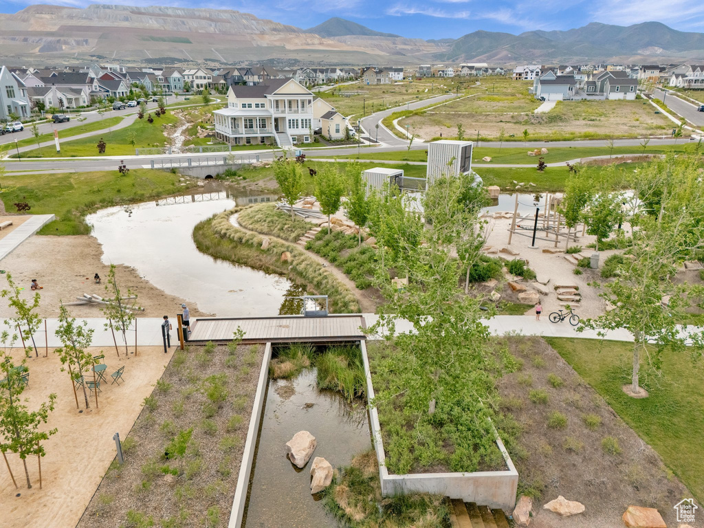 Aerial view of property and surrounding area featuring nearby suburban area and a mountain backdrop