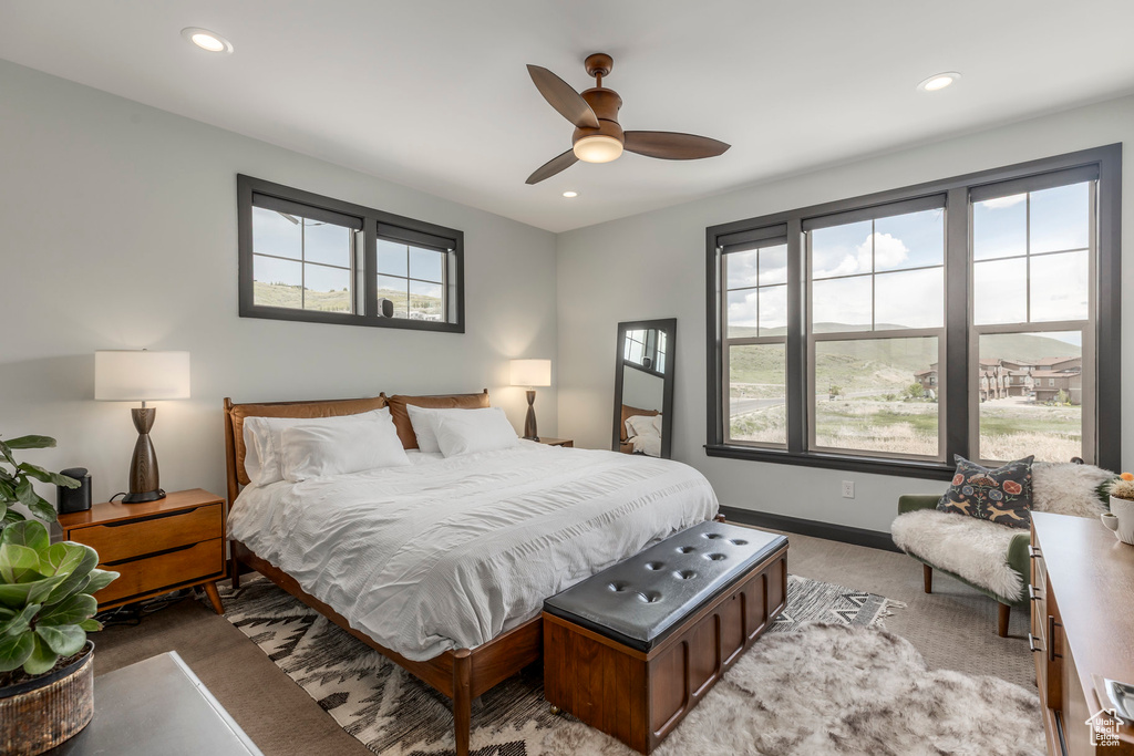 Bedroom featuring multiple windows, light carpet, baseboards, recessed lighting, and a ceiling fan