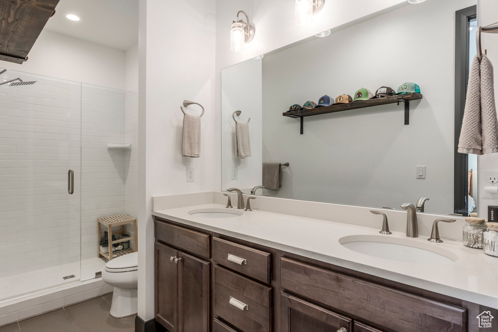 Bathroom featuring toilet, a shower stall, tile patterned flooring, double vanity, and recessed lighting