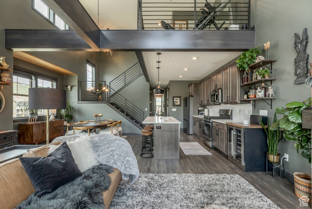 Living room featuring wine cooler, dark wood finished floors, stairs, recessed lighting, and baseboards