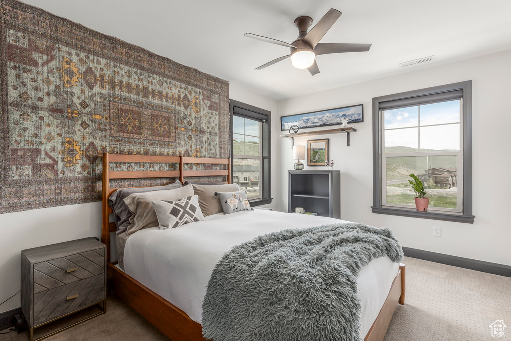 Bedroom with carpet, baseboards, and a ceiling fan