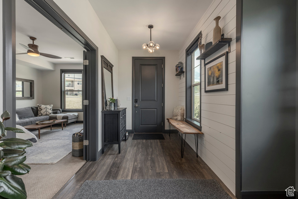 Foyer entrance featuring dark wood finished floors, a chandelier, and ceiling fan
