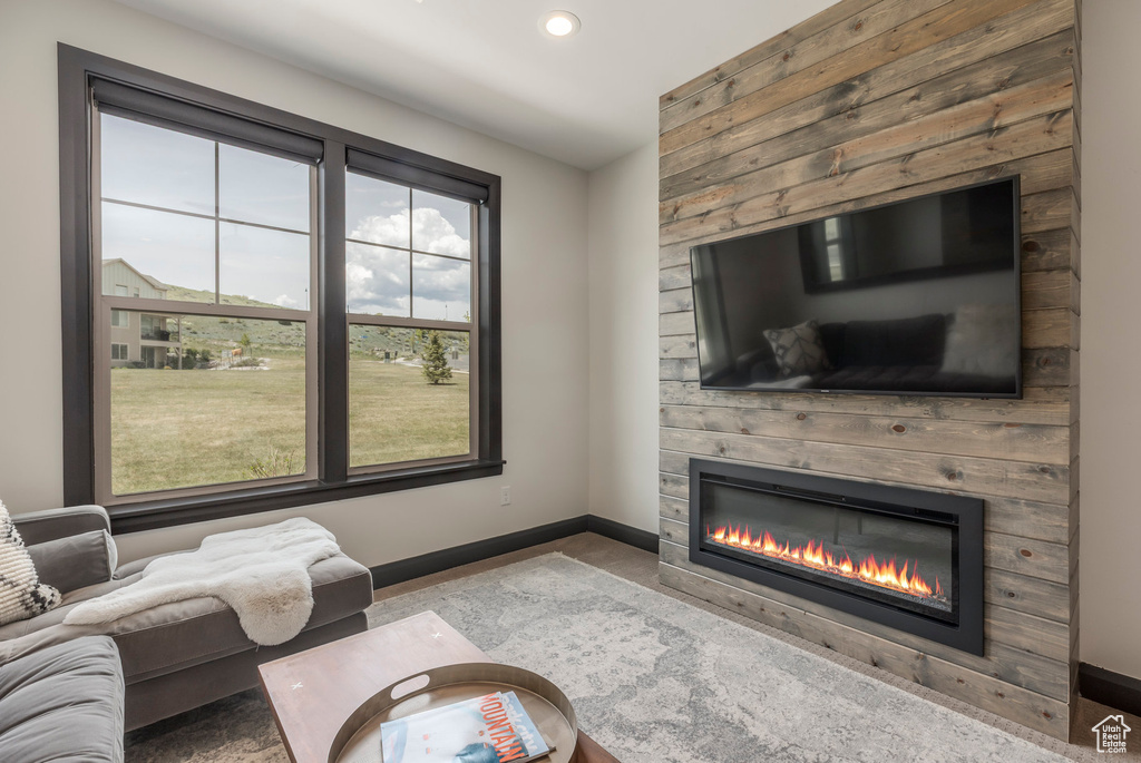 Living area with a large fireplace, baseboards, and recessed lighting