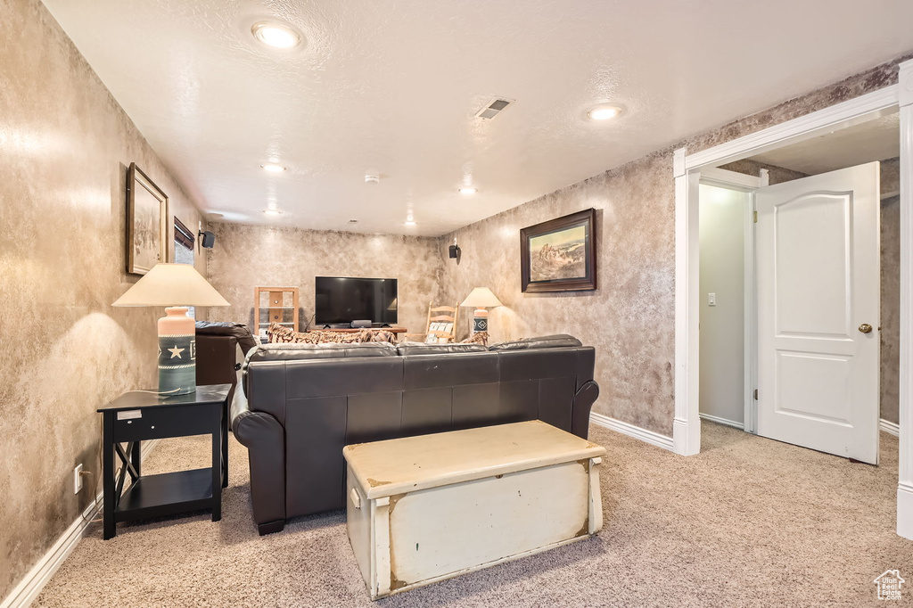 Living area featuring light colored carpet, baseboards, and recessed lighting