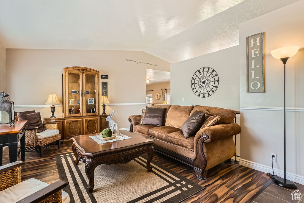 Living area with dark wood-style floors and vaulted ceiling