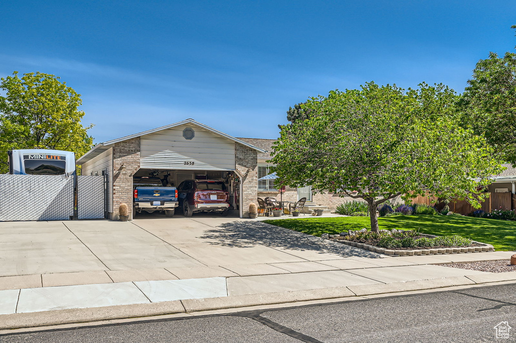View of front of home featuring concrete driveway, brick siding, and an attached garage