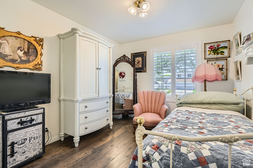 Bedroom with dark wood-type flooring and baseboards
