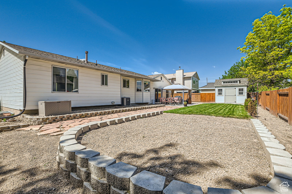 Rear view of property featuring a patio area, central AC unit, and a gazebo