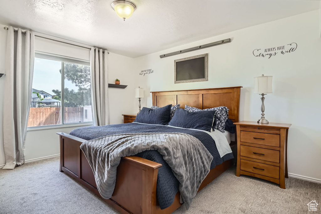 Bedroom with light colored carpet and baseboards