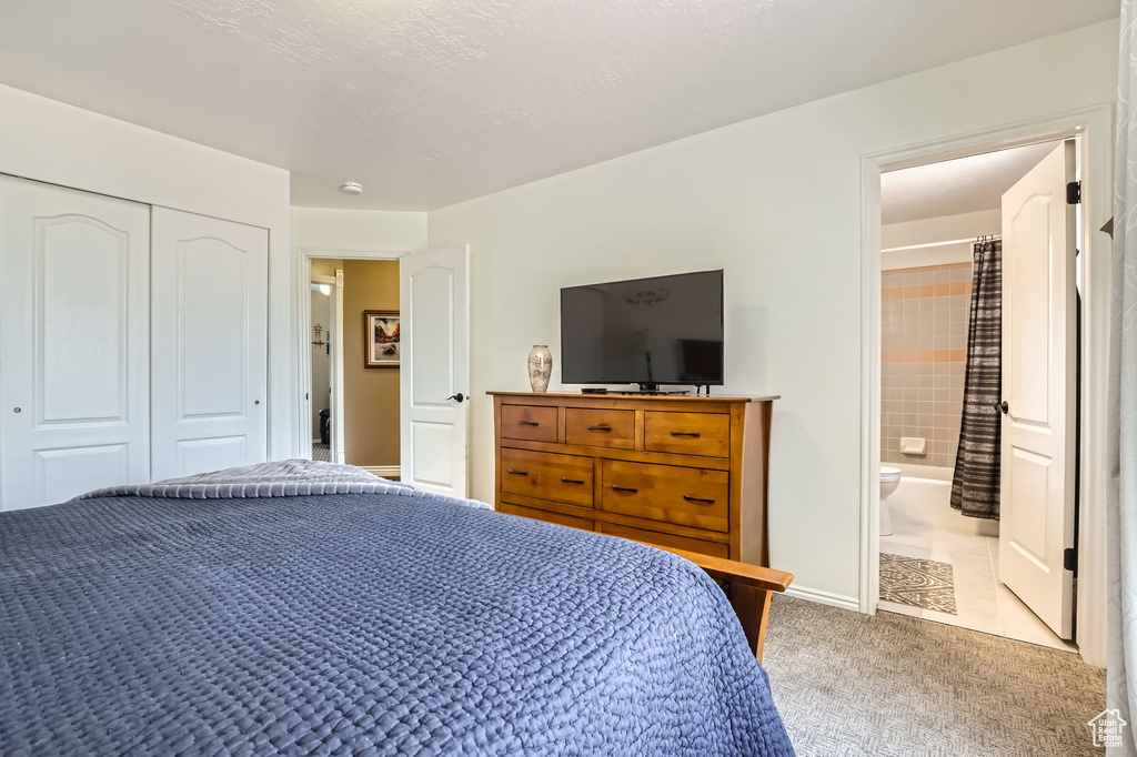 Carpeted bedroom with a closet and ensuite bathroom