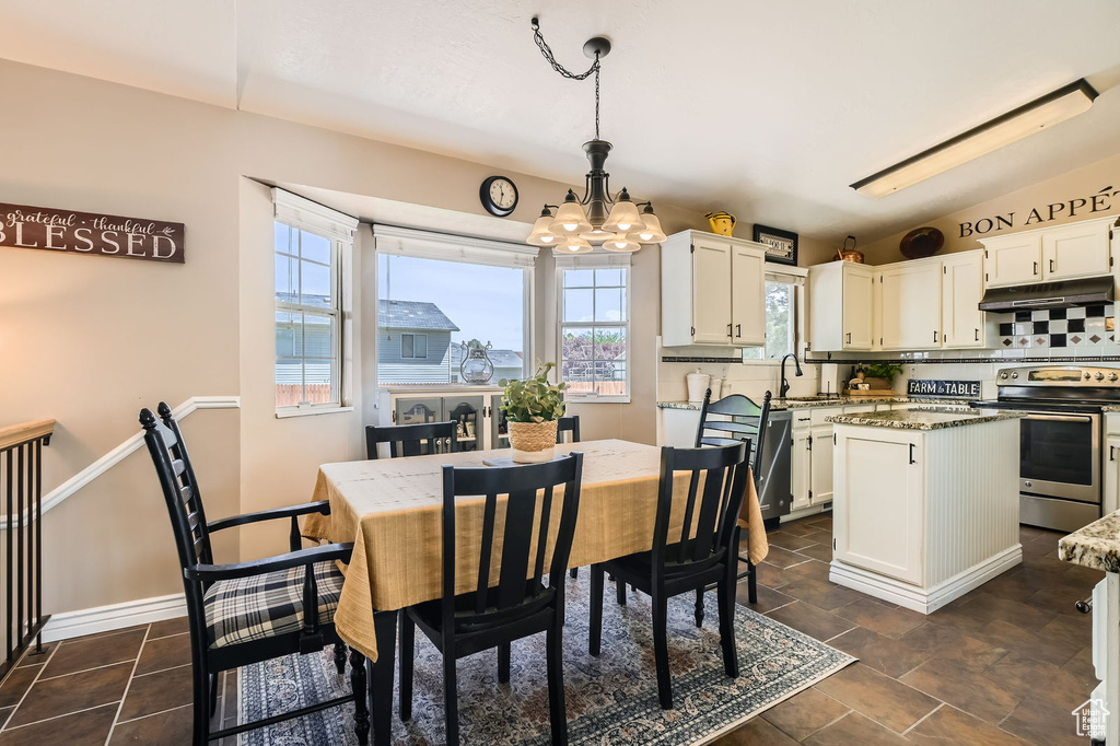 Dining area with a chandelier and baseboards