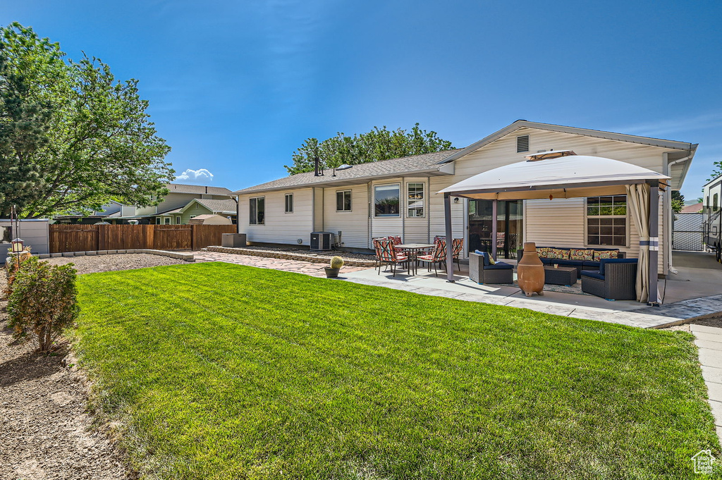 Rear view of property with an outdoor hangout area, a patio area, and a gazebo