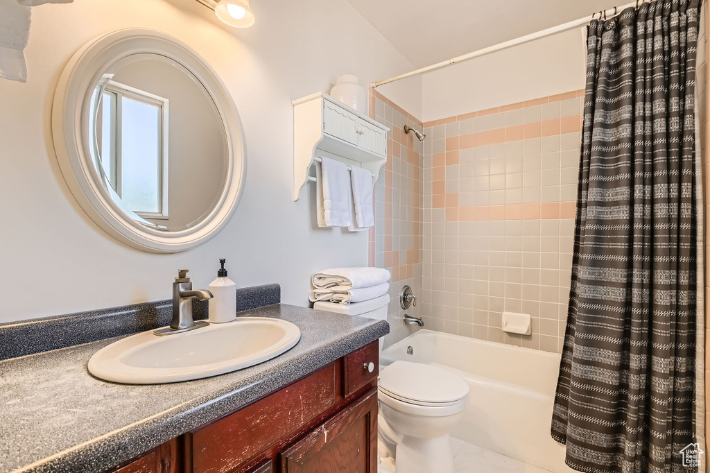 Full bathroom featuring shower / bath combo, vanity, and toilet