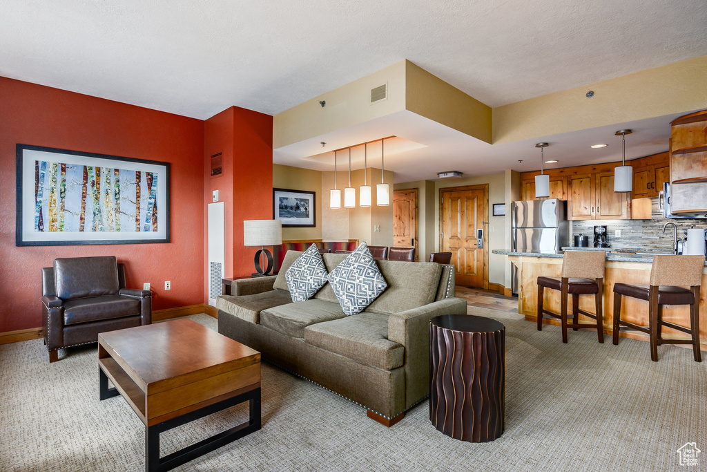 Living room with light colored carpet, baseboards, and recessed lighting