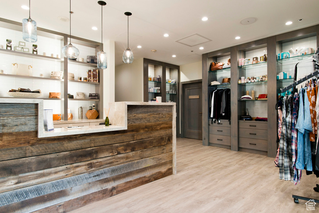 Kitchen with open shelves, light wood-style floors, pendant lighting, and recessed lighting
