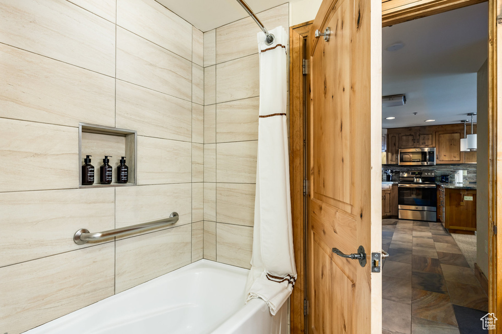 Bathroom with shower / tub combo and vanity