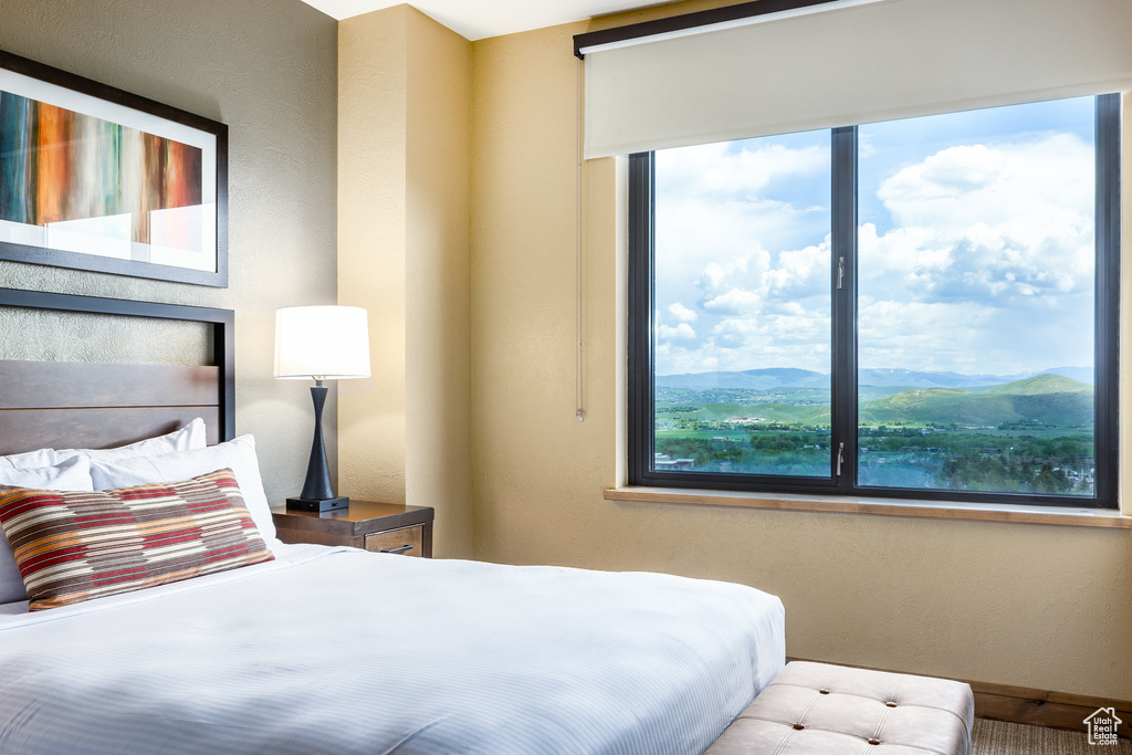Bedroom with multiple windows and a mountain view