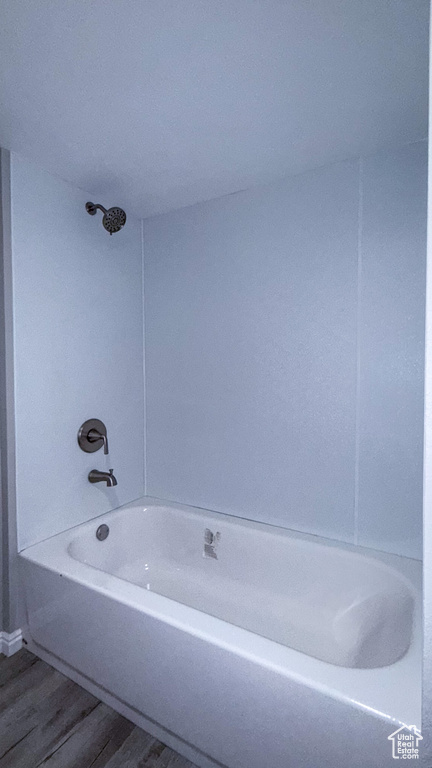 Bathroom featuring wood finished floors and washtub / shower combination