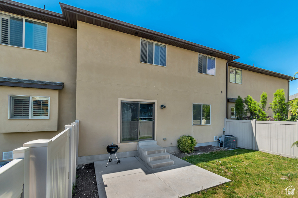 Rear view of house featuring a patio, stucco siding, entry steps, and central air condition unit