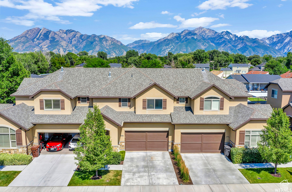 View of front of house featuring stucco siding, concrete driveway, and an attached garage
