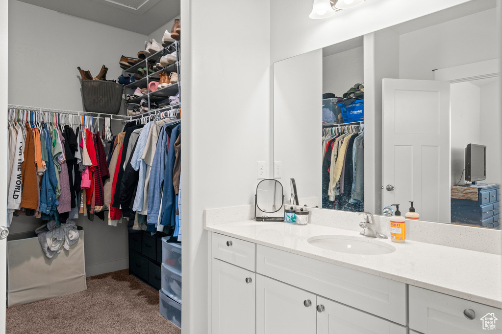 Bathroom with vanity and a walk in closet