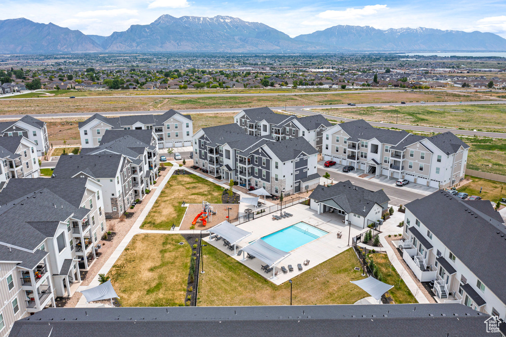 Aerial perspective of suburban area featuring a pool area and a mountainous background