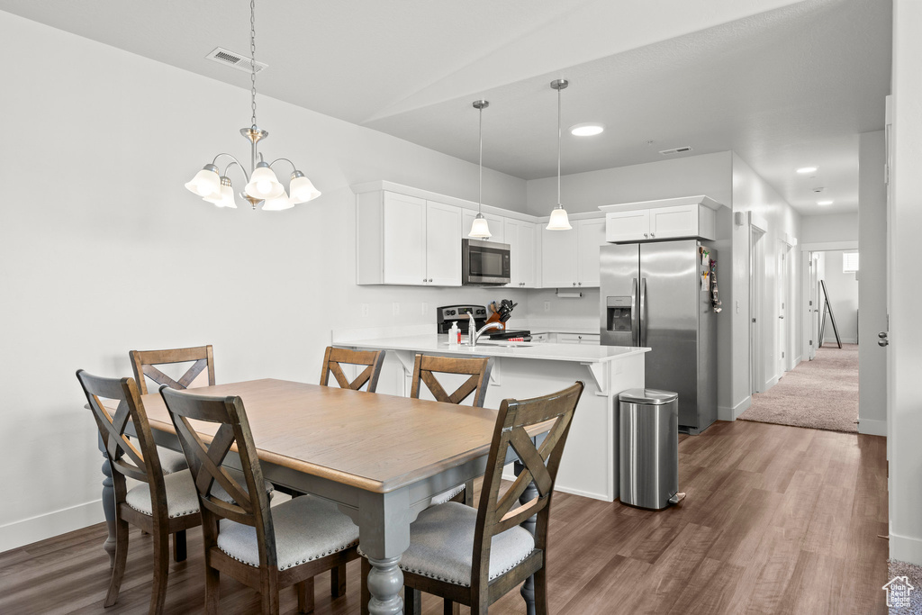 Dining space with baseboards, dark wood finished floors, a chandelier, and recessed lighting
