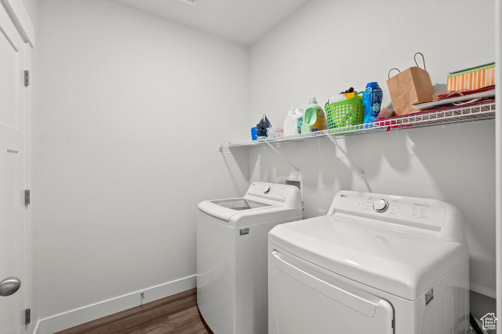 Laundry room featuring independent washer and dryer, dark wood finished floors, and baseboards