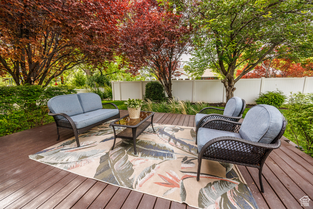 Wooden terrace with a fenced backyard and an outdoor living space