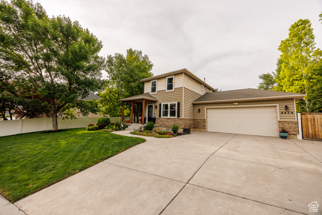 View of front of home with concrete driveway, a garage, and stone siding