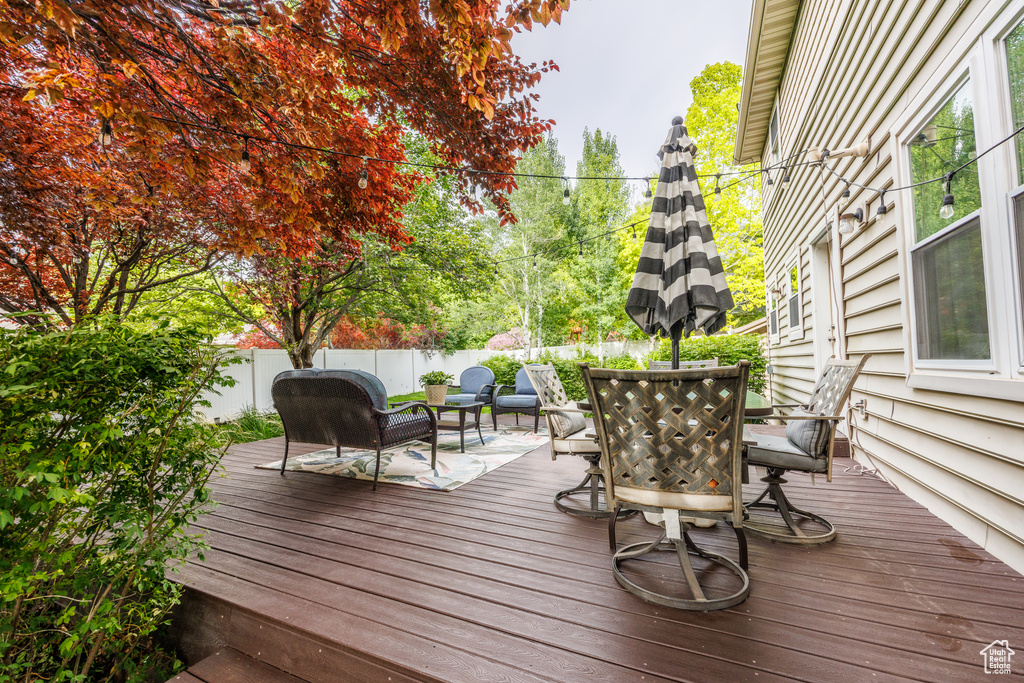 Wooden terrace featuring a fenced backyard and outdoor dining area