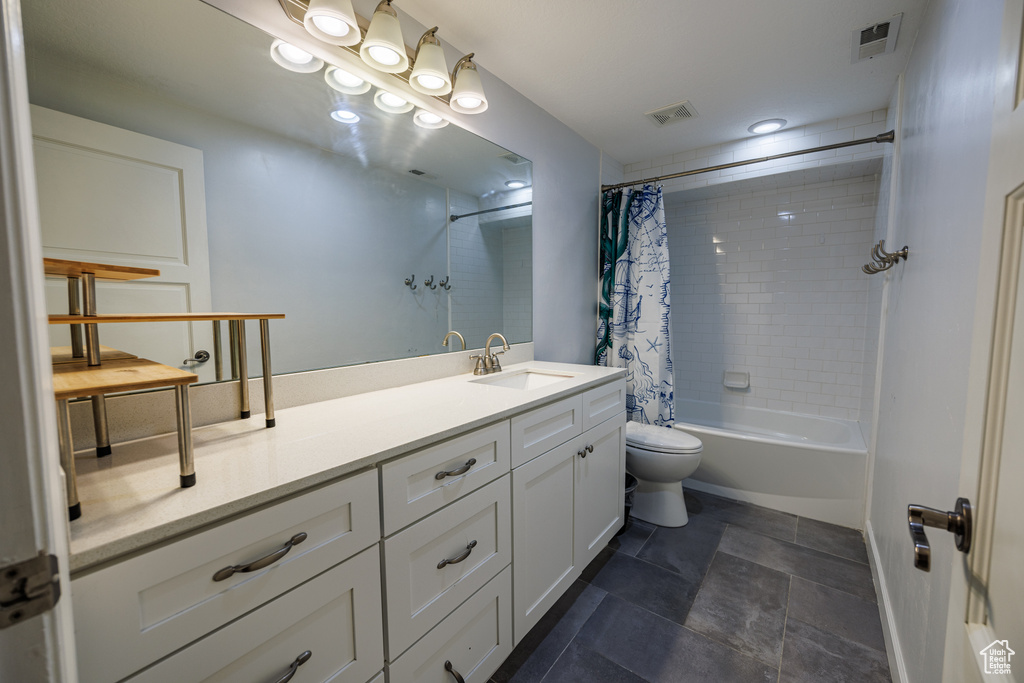Full bathroom with vanity, toilet, shower / tub combo, and stone finish flooring