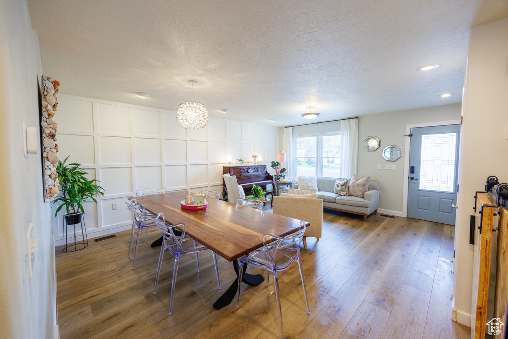 Dining area featuring hardwood / wood-style flooring, recessed lighting, and a chandelier