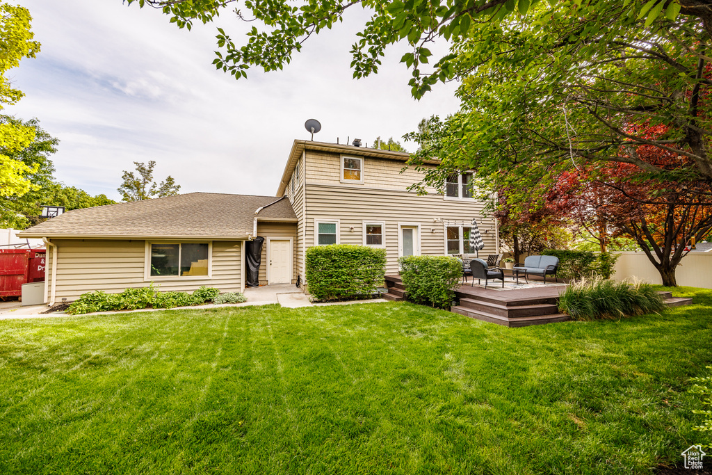 View of front of house with a wooden deck and a shingled roof