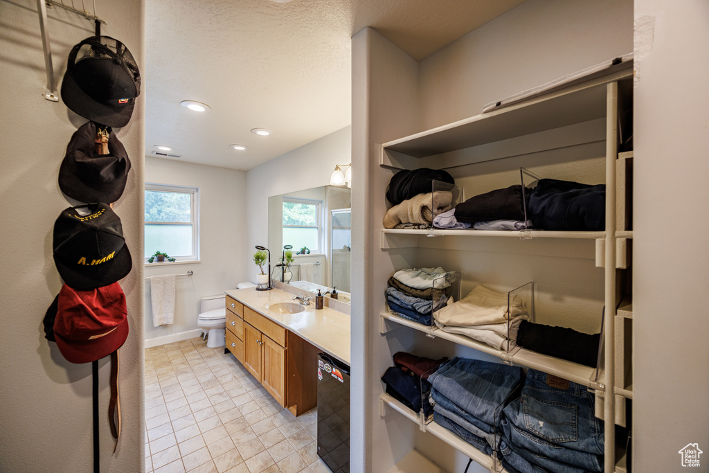 Bathroom with vanity, toilet, tile patterned flooring, recessed lighting, and baseboards
