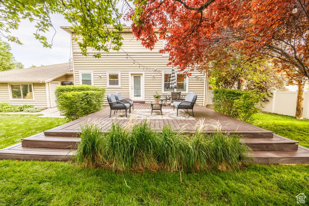 Rear view of property featuring a deck and outdoor lounge area