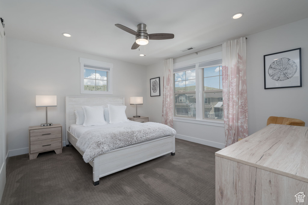 Bedroom with dark colored carpet, baseboards, recessed lighting, and ceiling fan