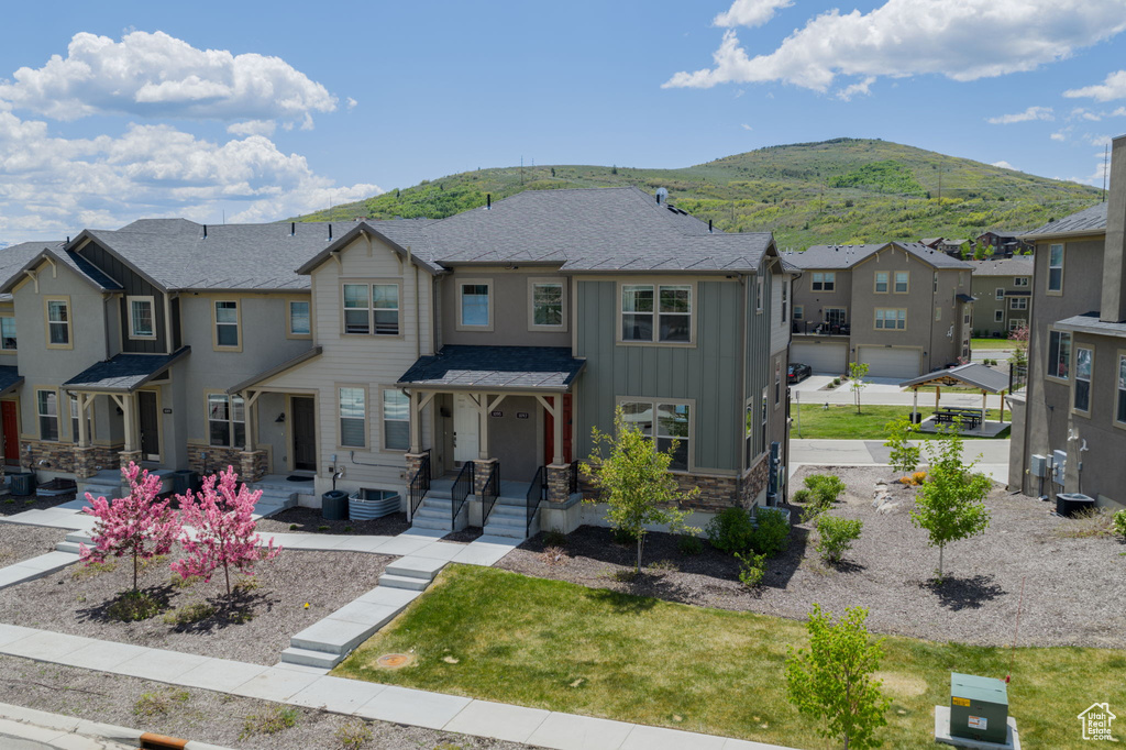 View of front facade with board and batten siding, a residential view, a mountain view, and stone siding