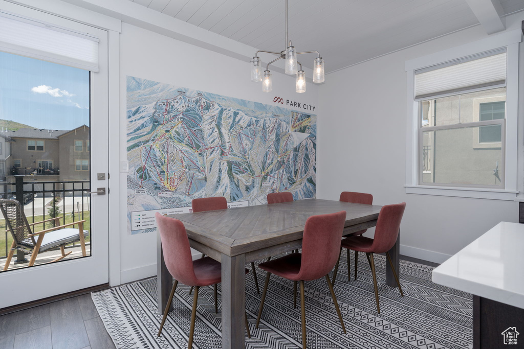 Dining room featuring wood finished floors, baseboards, and beamed ceiling