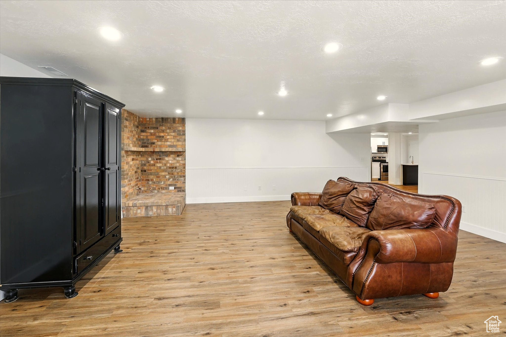 Living room with light wood finished floors, recessed lighting, and baseboards