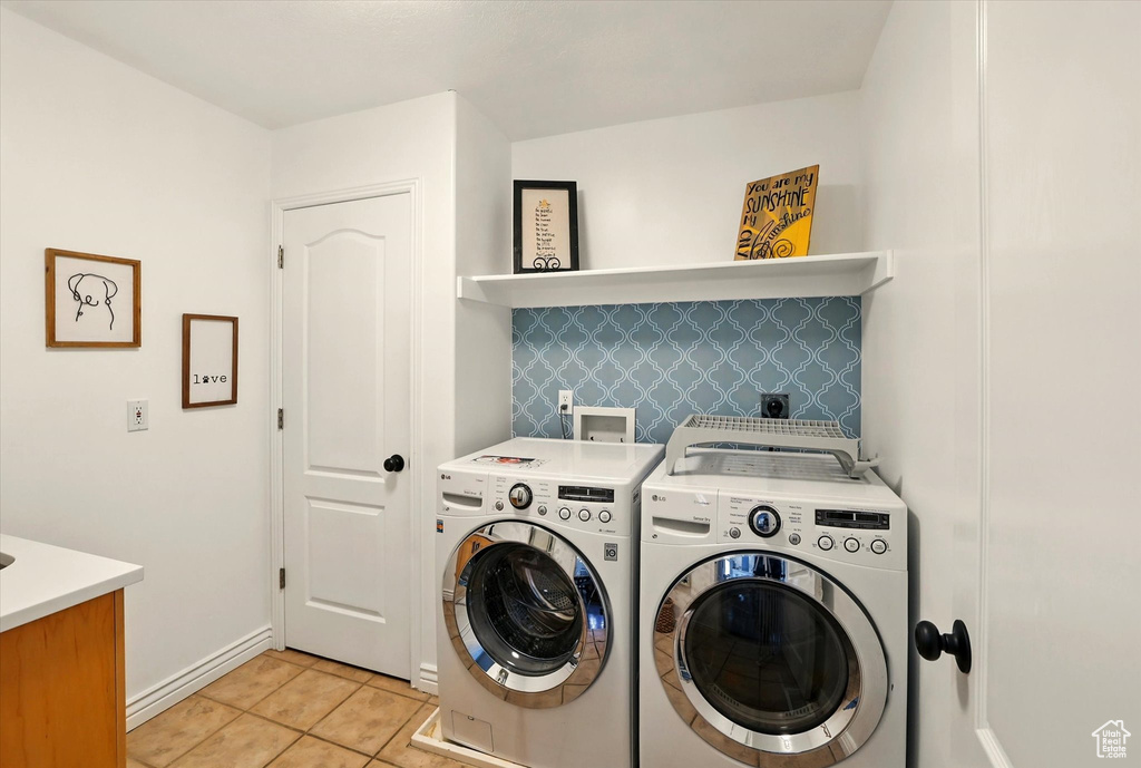 Washroom with separate washer and dryer, light tile patterned floors, and baseboards