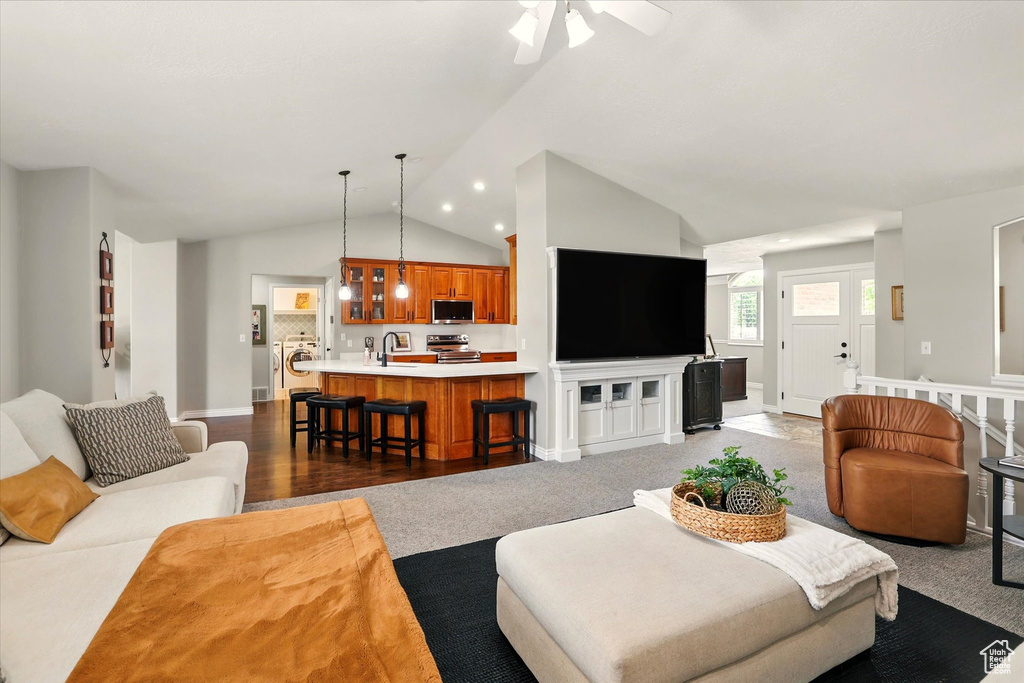 Living area featuring lofted ceiling, washer / clothes dryer, ceiling fan, and baseboards