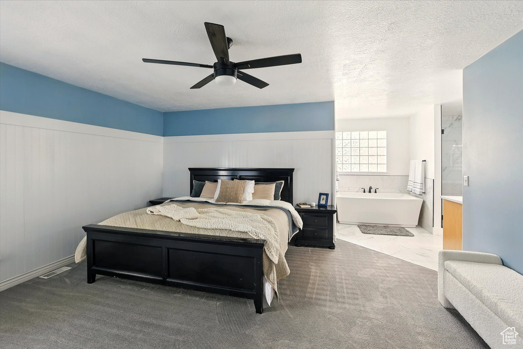 Carpeted bedroom with ceiling fan and ensuite bathroom